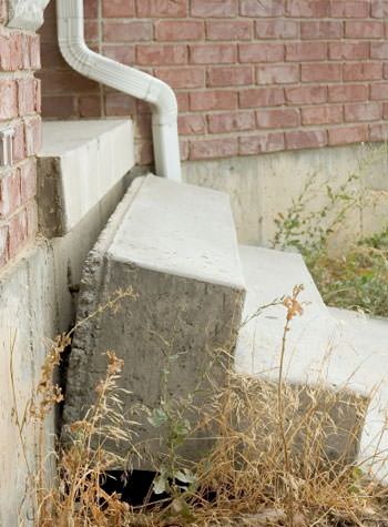 sinking outdoor concrete steps showing cracking and soil washout in Grandview