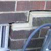 A closeup of a failed tuckpointing job where the brick cracked on a Raymore home.