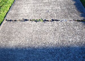 A sinking concrete sidewalk in need of mudjacking services in Kansas City.